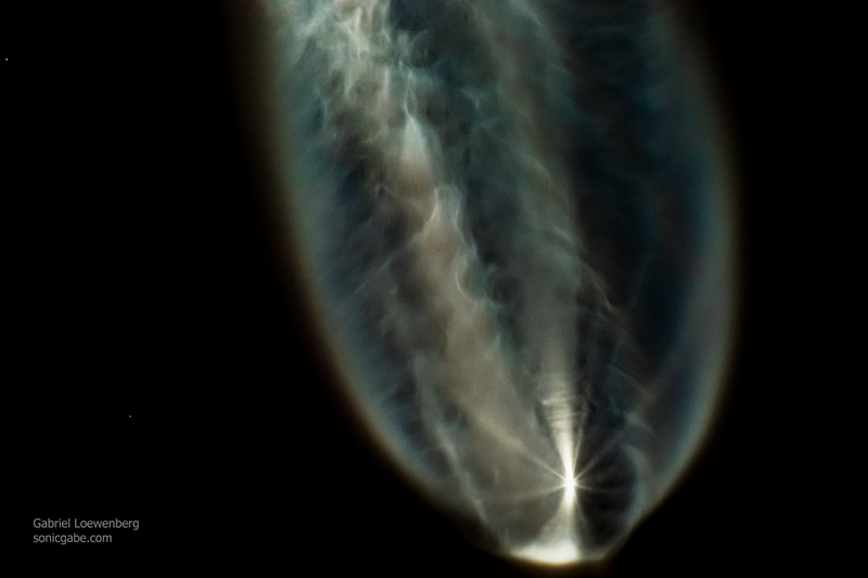 The two white dots on the left side are two of the five boosters as they fall away from the main rocket.